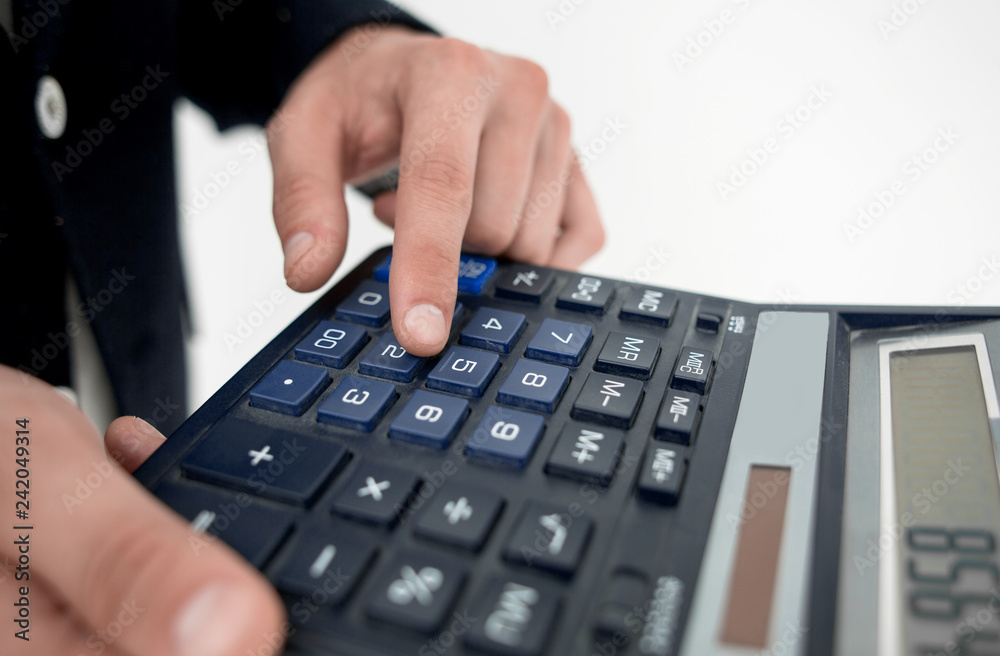 close up.the businessman uses the calculator. close up.the businessman uses the calculator.