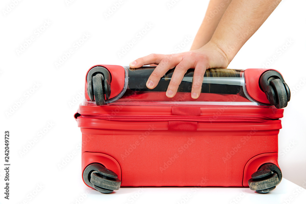 The man tries to cram and close the suitcase. Travel concept, packing up before departure. Preparing for travel, going on vacation, break, rest. Business trip, delegation. The man tries to cram and close the suitcase. Travel concept, packing up before departure. Preparing for travel, going on vacation, break, rest. Business trip, delegation.