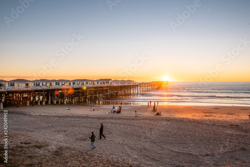 People doing activities at the beach near the pier with beautiful sunset. Pacific Beach in San Diego, California