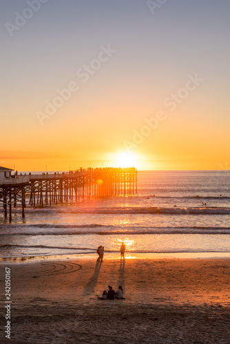 People doing activities at the beach near the pier with beautiful sunset. Pacific Beach in San Diego, California
