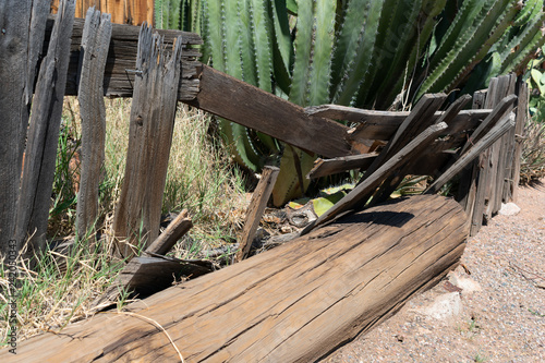 Collapsed wooden fence in front of an old abandoned building