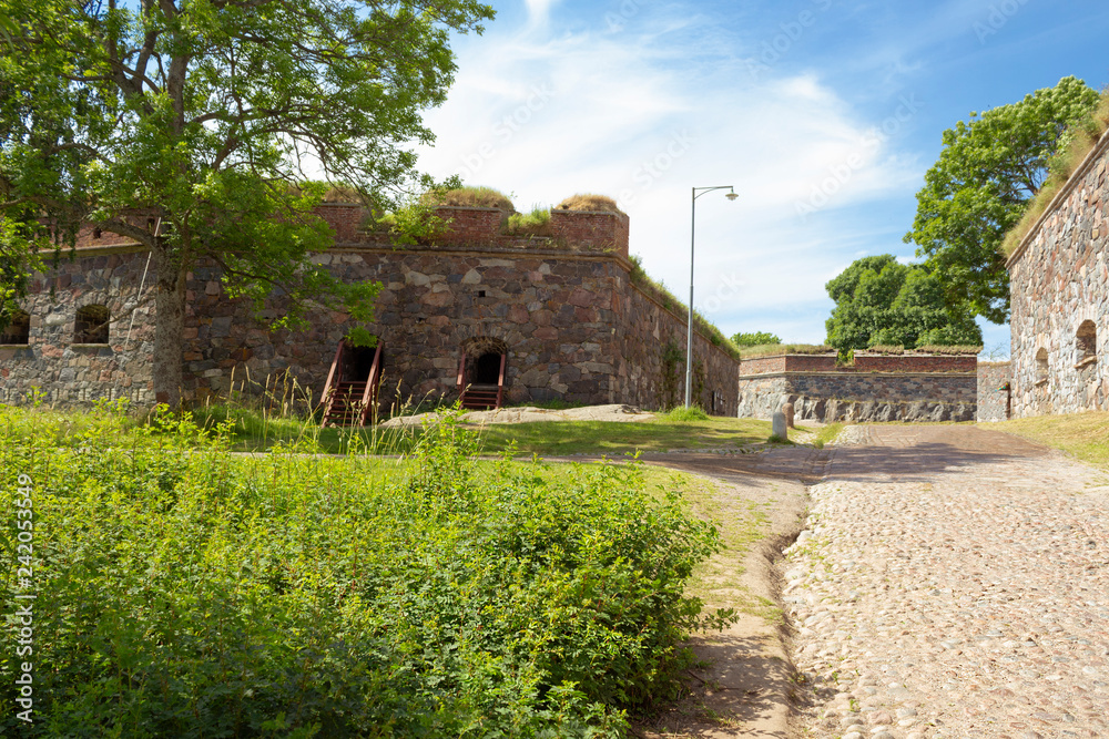 The old granite walls of the historic fortifications on Suomenlinna Forte Island are overgrown with grass in summer. Suomenlinna Island in the Gulf of Finland are tourist attractions.