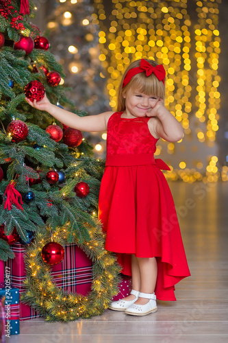 Little girl decorating christmas tree. Christmas. New Year. Christmas eve. Holiday. Indoor. Home.
