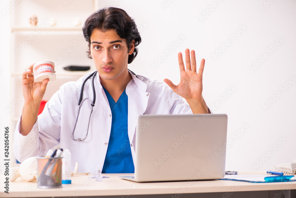 Young male doctor stomatologist with dentures Young male doctor stomatologist with dentures