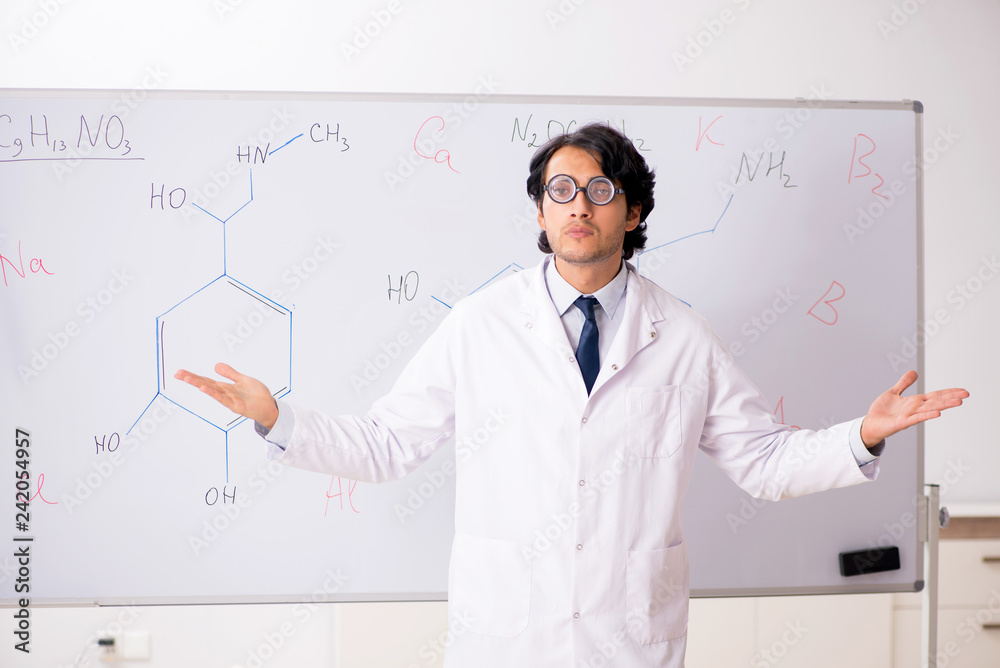 Young funny chemist in front of white board Young funny chemist in front of white board