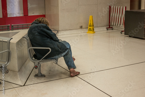 homeless man sleep s on a bench at a subwat station