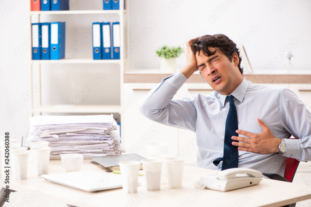 Young employee addicted to coffee Young employee addicted to coffee