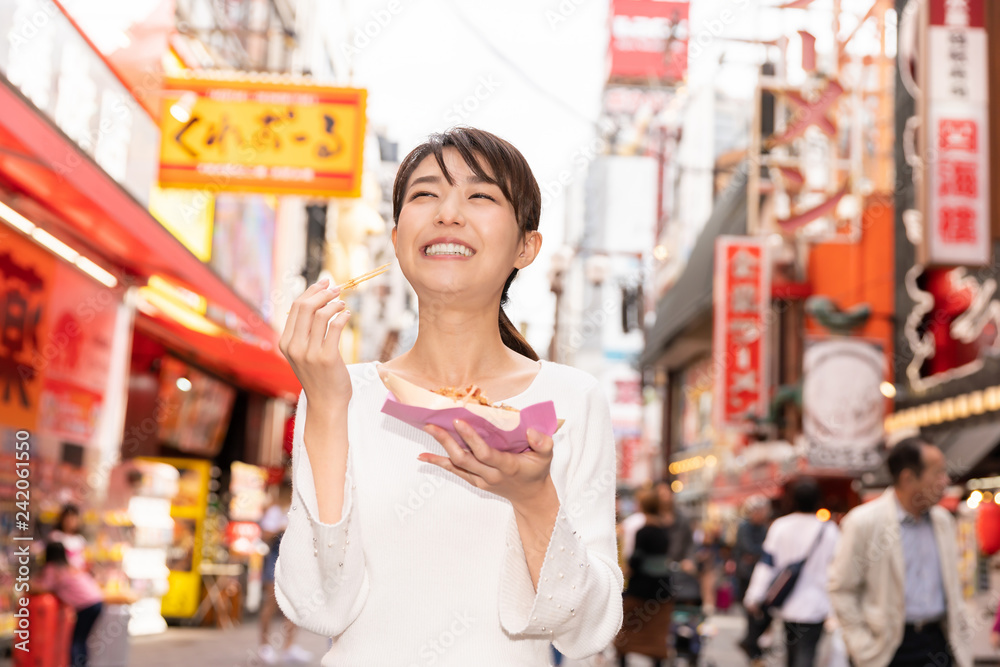 大阪でたこ焼きを食べる女性