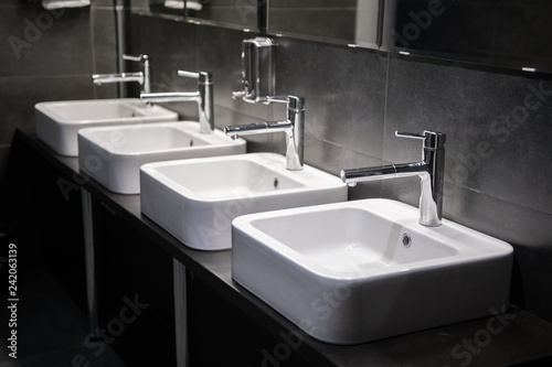 Modern sinks with mirror in public toilet photo