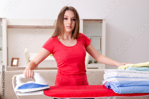 Young beautiful woman ironing at home   photo