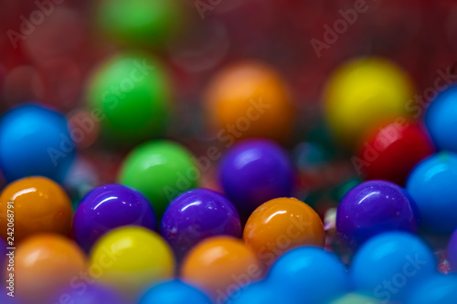 Multicolored round candy balls with out of focus background.