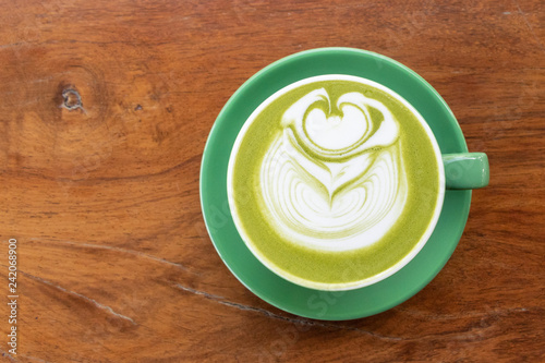 Coffee cup with Green Matcha latte art foam on wood table in coffee shop with copy space.Coffee is one of the most popular beverages.Improve Energy Levels and Burn Fat