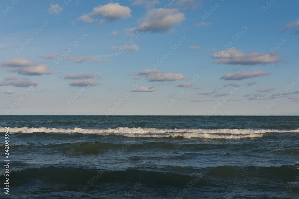 Lake Michigan on a beautiful Autumn morning with blue skies and clouds above.  Indiana Dunes, Indiana, USA