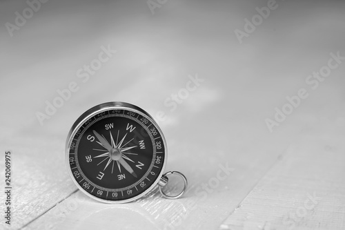 Compass with clear white wooden wall background, vintage tone, journey planning concept, blank space, top view