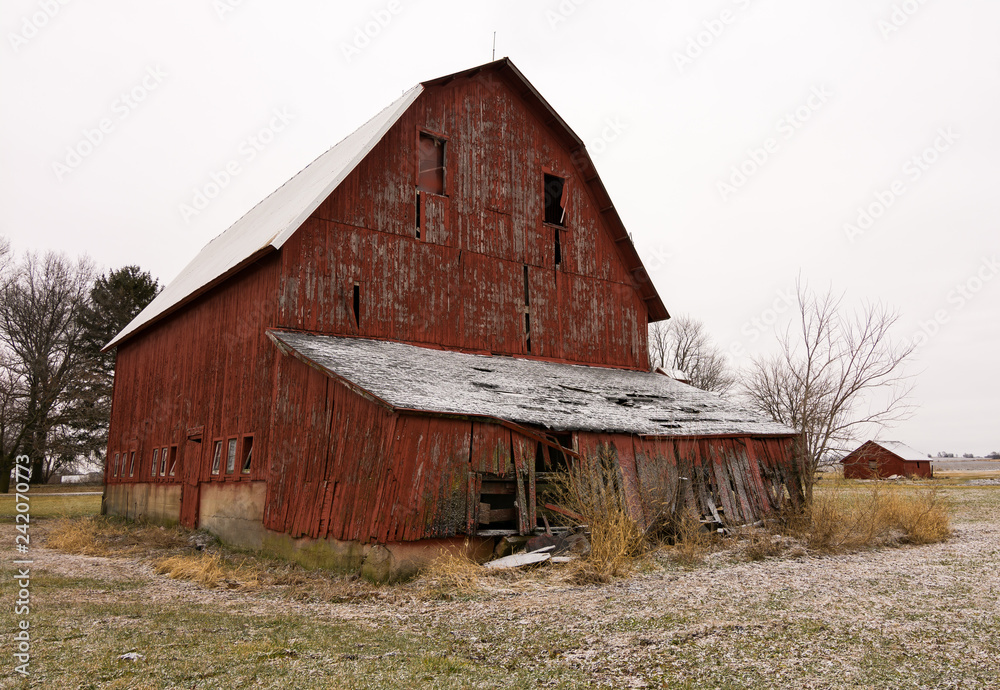 Old red barn in the rural countryside after a morning snow dusting.  Norway, Illinois, USA