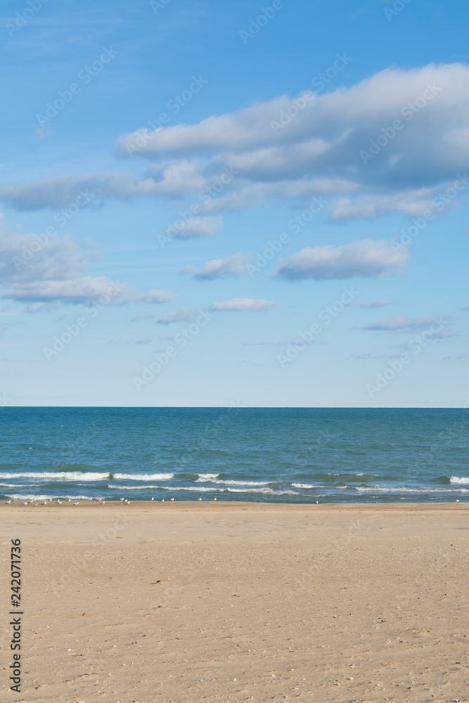 Lake Michigan on a beautiful Autumn morning with blue skies and clouds above.  Indiana Dunes, Indiana, USA
