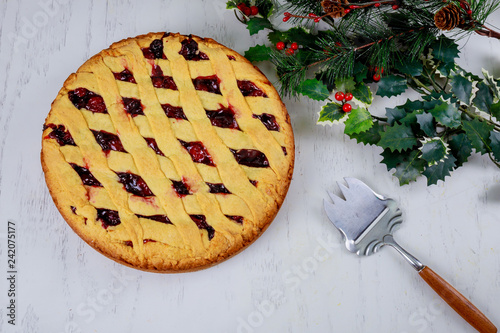 Christmas cherry pie cake with wooden background. Winter Holiday a fir tree Food Dessert Concept. Top view, copy space