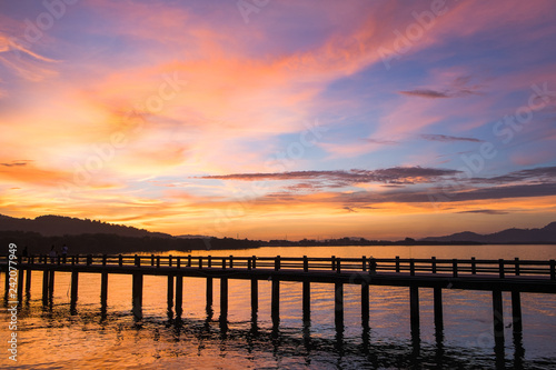 The bridge that stretches in the middle of the sea at sunset is like heaven. © Takorn