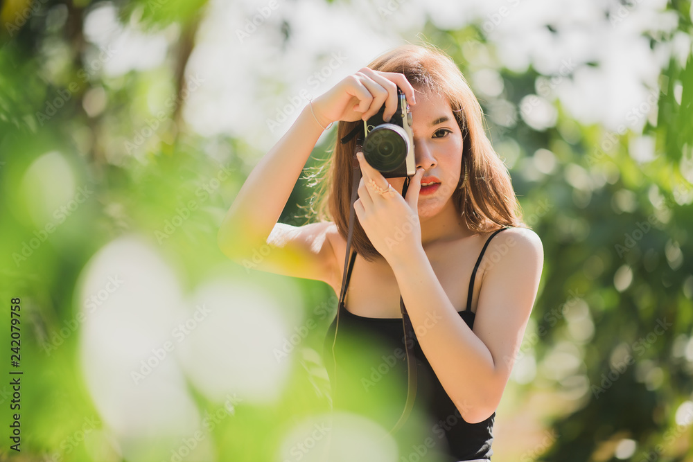 Portrait of asian woman is a professional photographer with mirrorless camera, outdoor portrait, free from copy space.
