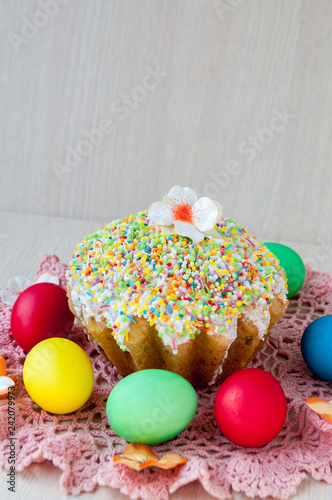 Easter cake on a table on a pink napkin and colorful eggs