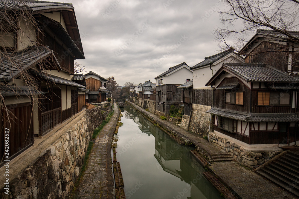 Historic wooden buildings line canal in old Japanese merchant village