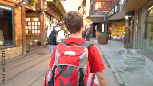 Young Backpacker Walking Through Swiss Mountain Village of Zermatt photo