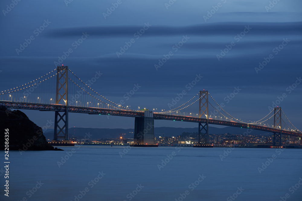 The San Francisco - Oakland Bay Bridge with San Francisco in the background during evening blue hour. The San Francisco - Oakland Bay Bridge with San Francisco in the background during evening blue hour.