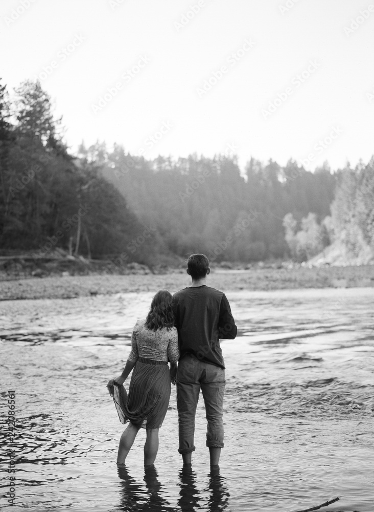 couple standing in river looking toward water