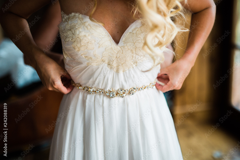 bride holding up bridal belt getting ready for wedding bride holding up bridal belt getting ready for wedding