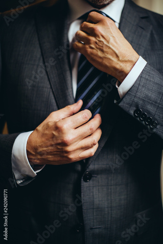 senior man putting on suit and tie