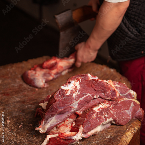 a butcher is chopping beef with an axe