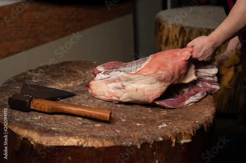 Close-up of the hands of a butcher cutting slices of raw lamb