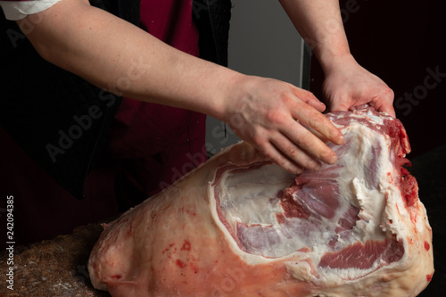 Close-up of the hands of a butcher cutting slices of raw lamb