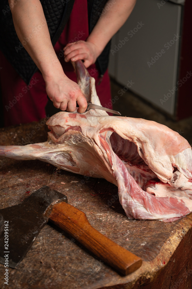 a butcher chopping meat lamb for steaks