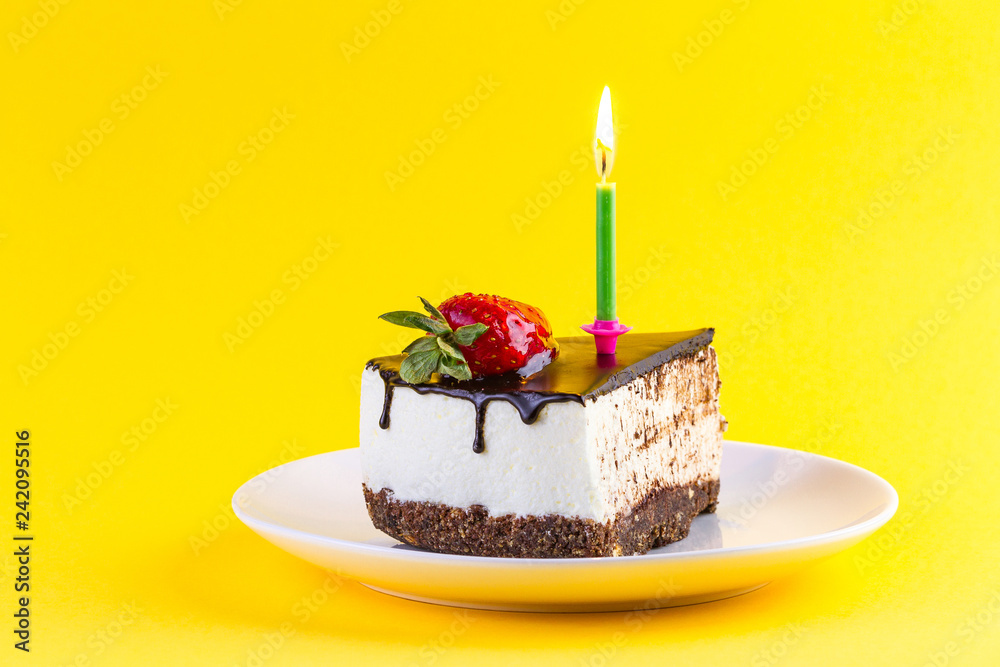 Strawberry cake with cream, dripping chocolate glaze and a lit candle ...