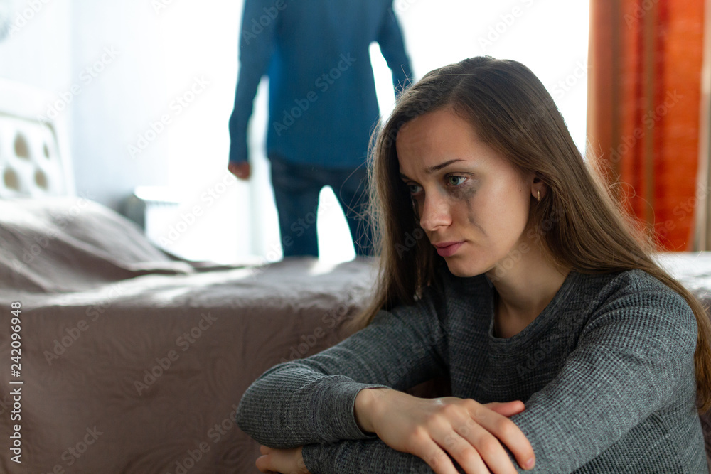Domestic, female violence. Crying woman sitting near the bed after an argument with her husband. Social and life problems Domestic, female violence. Crying woman sitting near the bed after an argument with her husband. Social and life problems