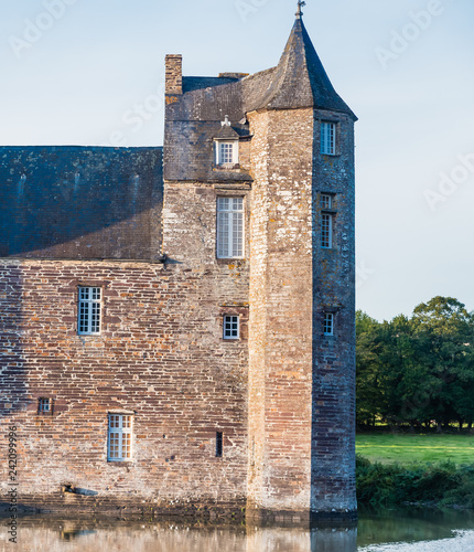 The turrets  of the 14th century Chateau de Trecesson in the Forest of Paimpont viewed across the large pool by which it is surrounded photo