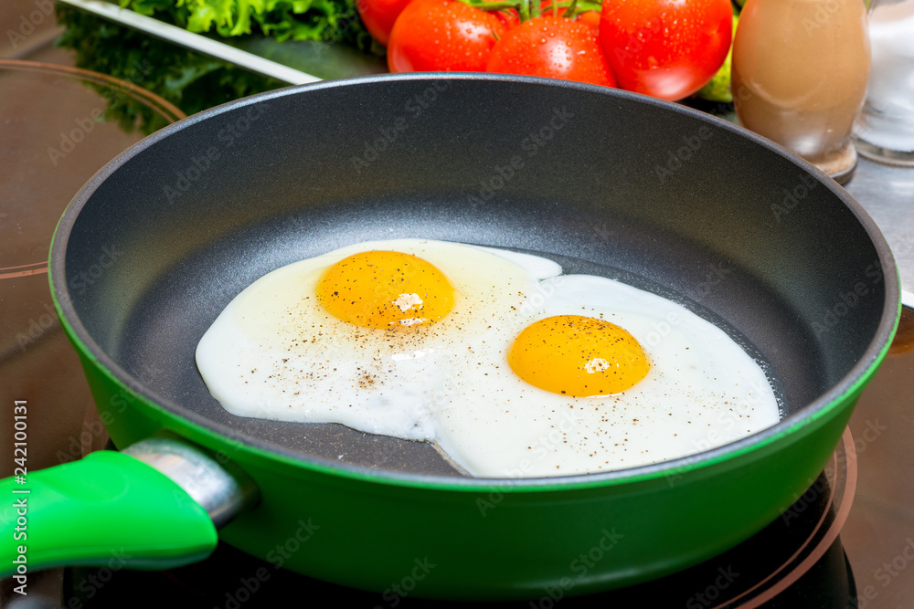 fried eggs in a frying pan fried on an electric plate close up fried eggs in a frying pan fried on an electric plate close up