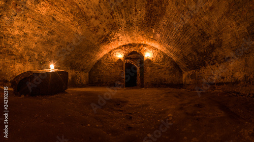 Scottish underground dungeon halls lit only by torchlight photo
