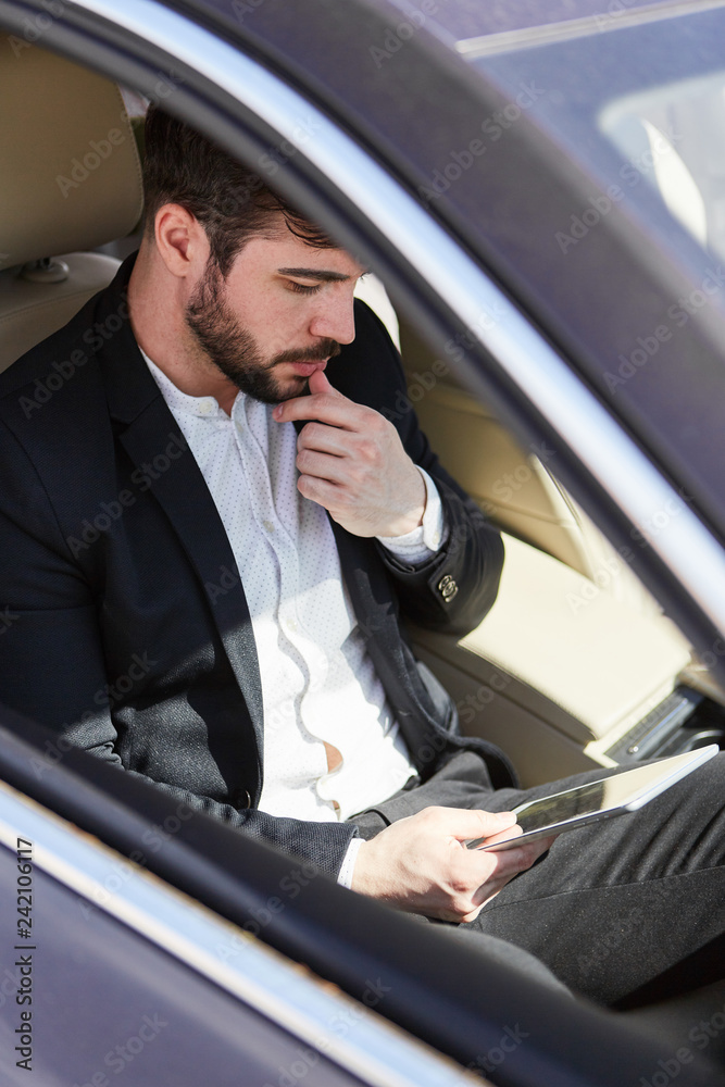 Geschäftsmann mit Tablet Computer im Auto
