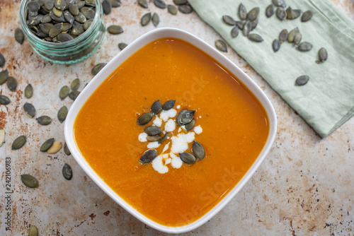 Home made pumpkin cream soup decorated with cream, seeds