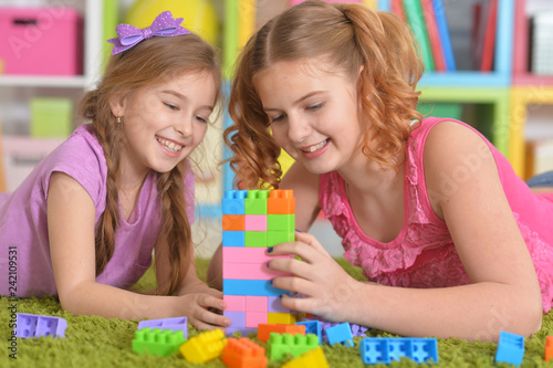 Cute girls playing with colorful plastic blocks