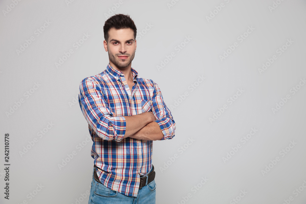 portrait of handsome casual man standing with arms folded portrait of handsome casual man standing with arms folded