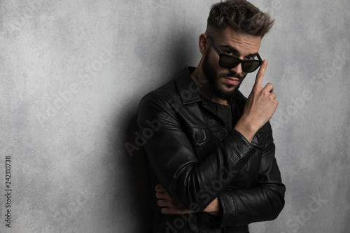 portrait of casual man in leather jacket touching his sunglasses © Viorel Sima