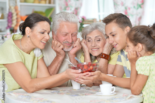 Close up portrait of big happy family eating fresh strawberries