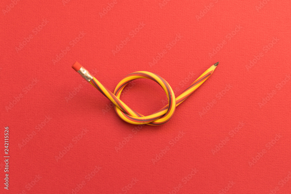 Flexible pencil . Isolated red background Flexible pencil . Isolated red background