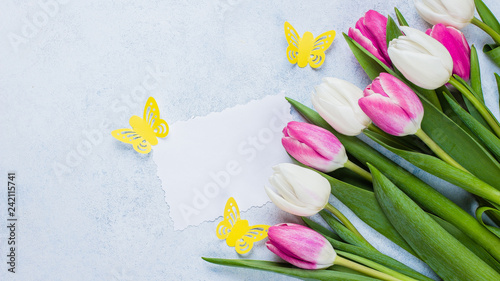 Fototapeta Naklejka Na Ścianę i Meble -  Spring Pink Tulips and Empty Paper Blank on blue stone background for Mother's Day, March 8. Easter Holiday Concept. Top view, flat lay, copy space