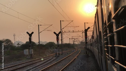 Sunset: passenger journey train rides in Indian Railways, Indian trains, all-coach train; way local traffic lights, sunset on the railway the sun's rays at sunset