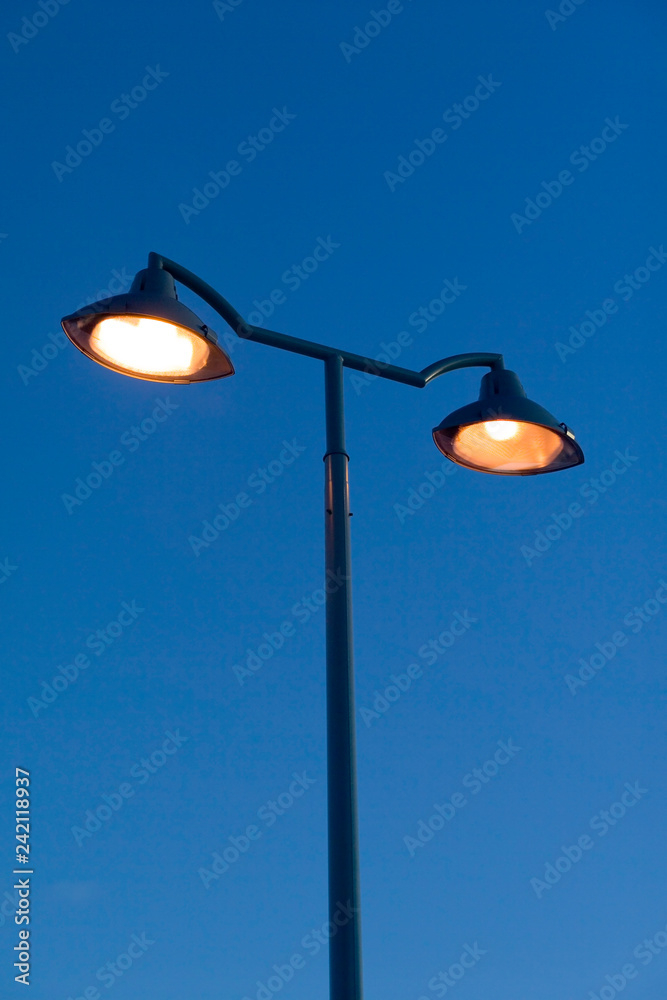 orange streetlamps against blue sky orange streetlamps against blue sky
