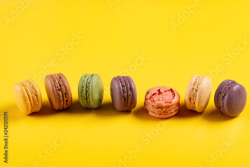 studio shoot of colorful macaroons line up on yellow background